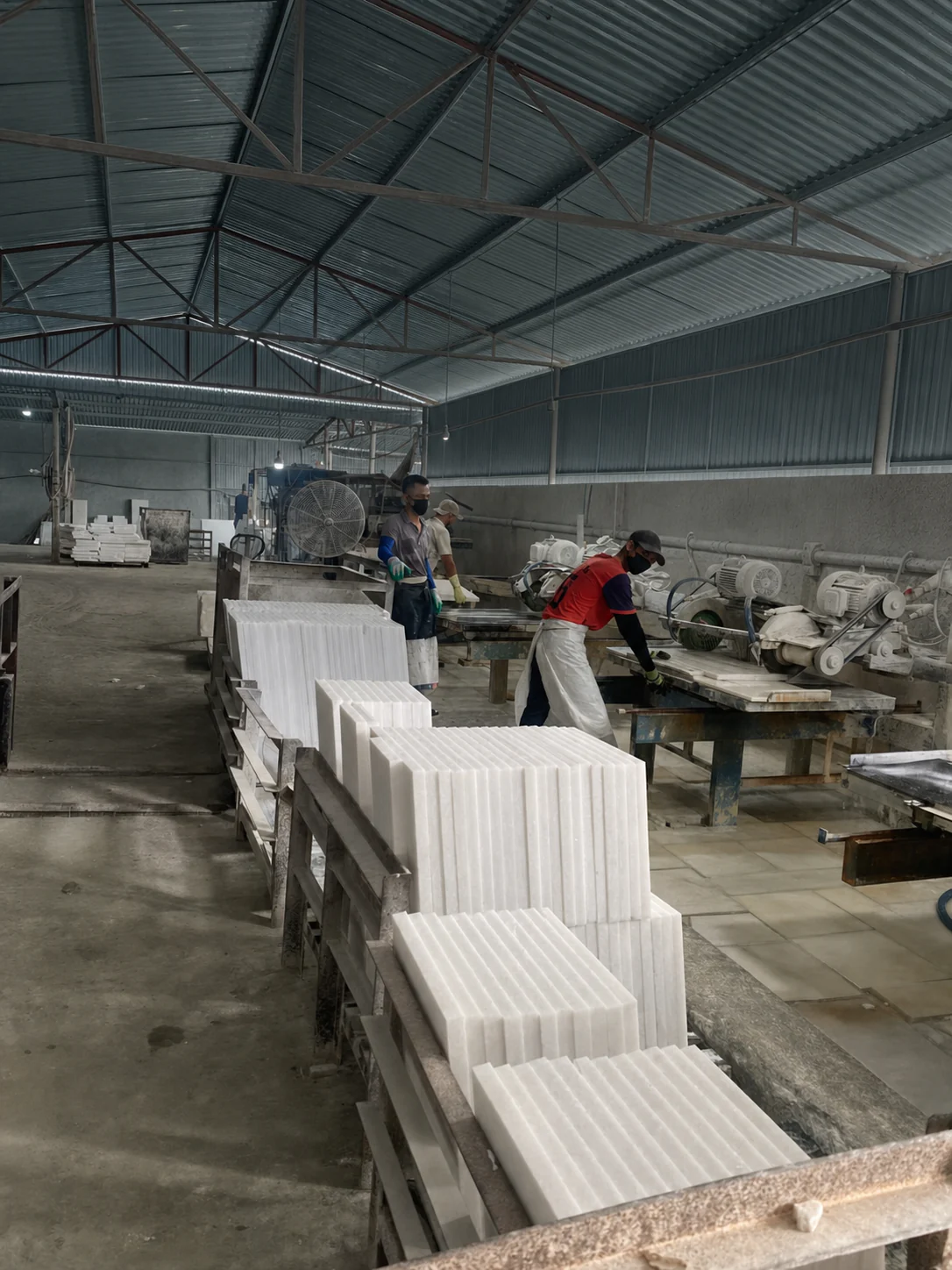 Công nhân hoàn thiện các tấm đá trắng trên dây chuyền mài